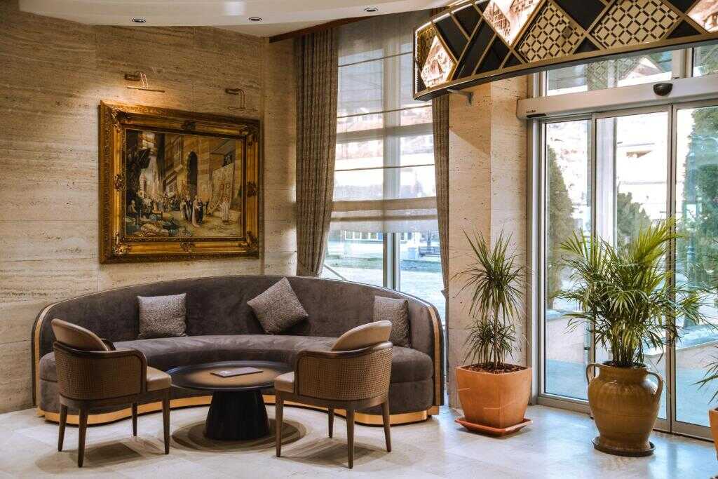 Lounge area with curved sofa and armchairs at Hotel Rožaje